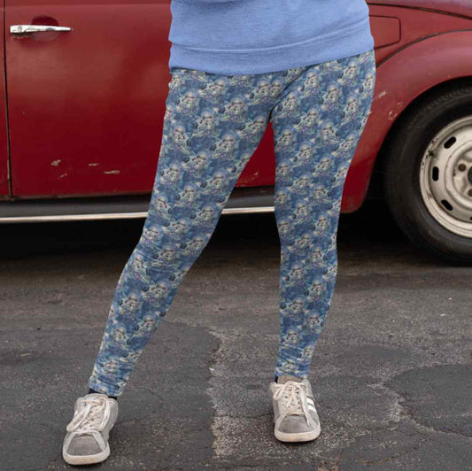 mockup-of-a-daring-woman-wearing-leggings-and-a-sweatshirt Wintry Dragonling Strangelings Leggings featuring an ethereal gothic-eyed fairy holding a baby dragon, set against a magical winter night sky in deep blues and lilac. by Nikki Whoops Boutique.