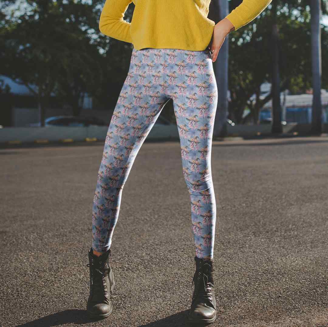 Person wearing Witch, Please Day of the Dead Skull Leggings featuring witch with pink hair, floral witches hat, and blue magical background by Nikki Whoops Boutique. and yellow top outdoors