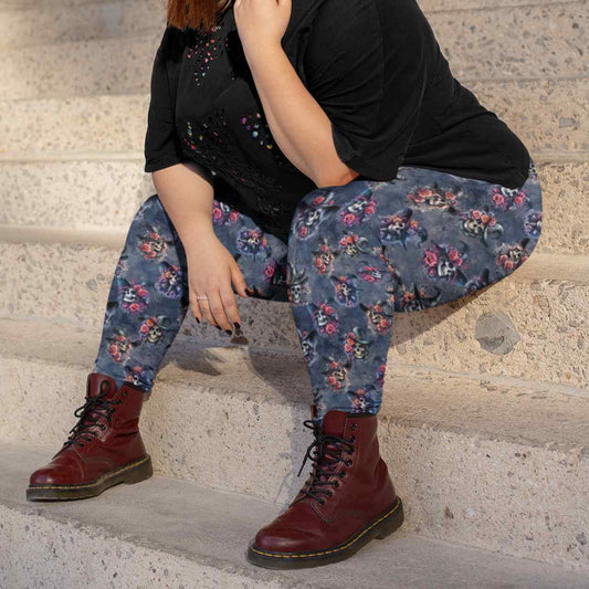 Woman sitting an stairs wearing plus-size leggings with witch skulls, flowers, and cobwebs on a dark background, worn by a woman sitting on stairs by Nikki Whoops Boutique.
